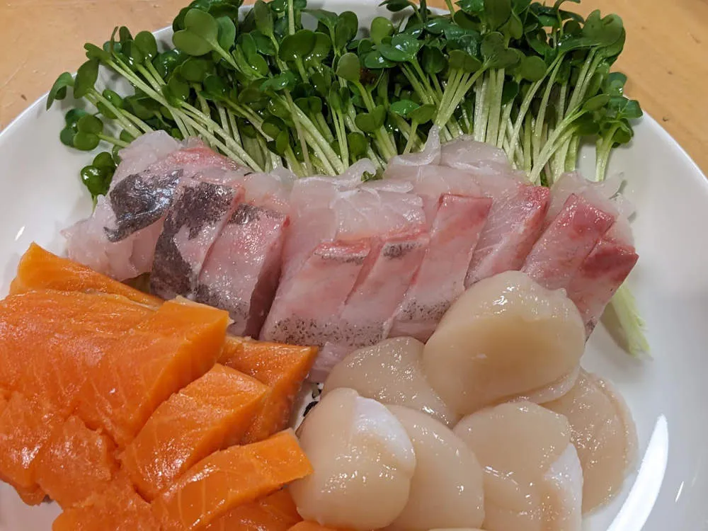 カンパチ、サーモン、ホタテ貝柱の刺身にカイワレを添えた贅沢盛